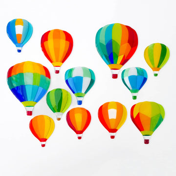 A collection of 12 fused glass hot air balloons by Glass Art by Linda. Unique designs in vivid colours in a Hard Edge glass art style