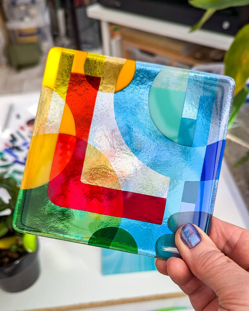 Close-up of commissioned 5-inch Alphabet glass Miniature featuring the letter L with an abstract Hard Edge background