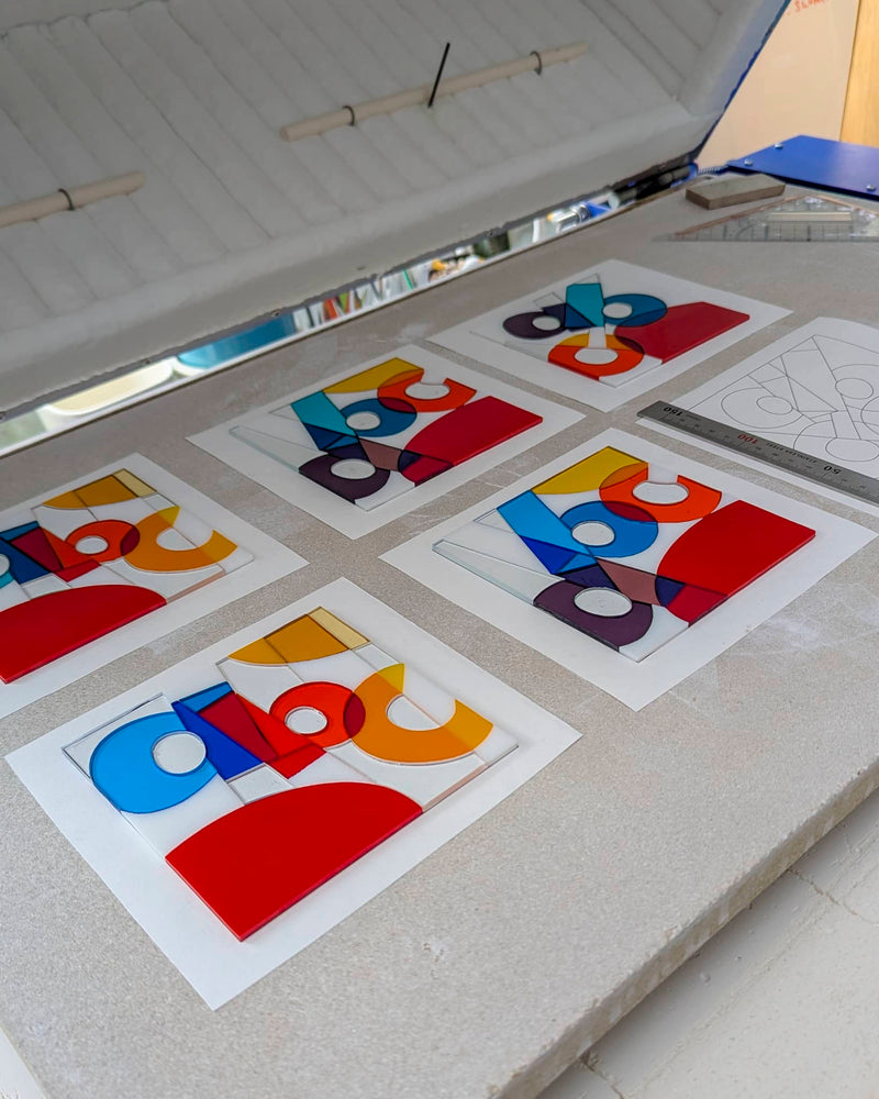Commissioned contemporary Hard Edge glass Miniature awards in progress showing individually cut glass pieces arranged before firing