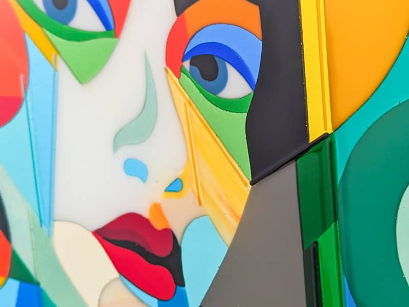 Commissioning art explained: Abstract artwork with a colorful face design on a blue background
