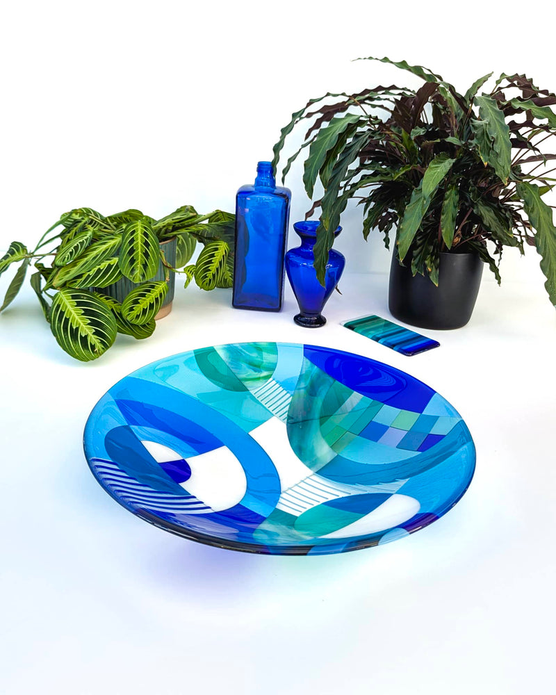Fused glass bowl titled 'Swirls' with dynamic blue hues and swirling patterns, exemplifying the Hard Edge art style