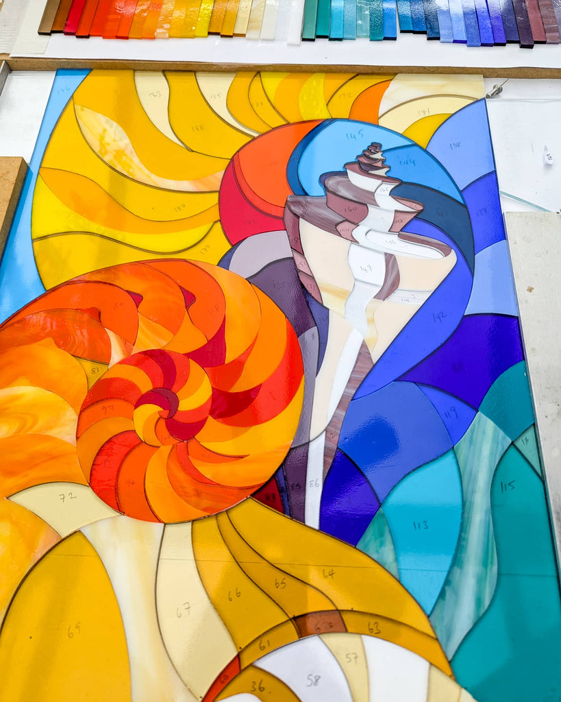 Work in progress Hard Edge fused glass panel with nautilus shell design, colourful cut glass sections laid out for bespoke commissioned artwork