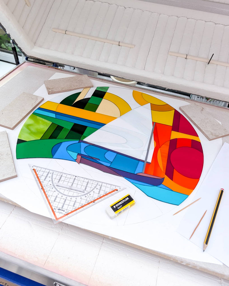 Beaulieu River fused glass roundel being assembled in the kiln from individually cut pieces of coloured glass