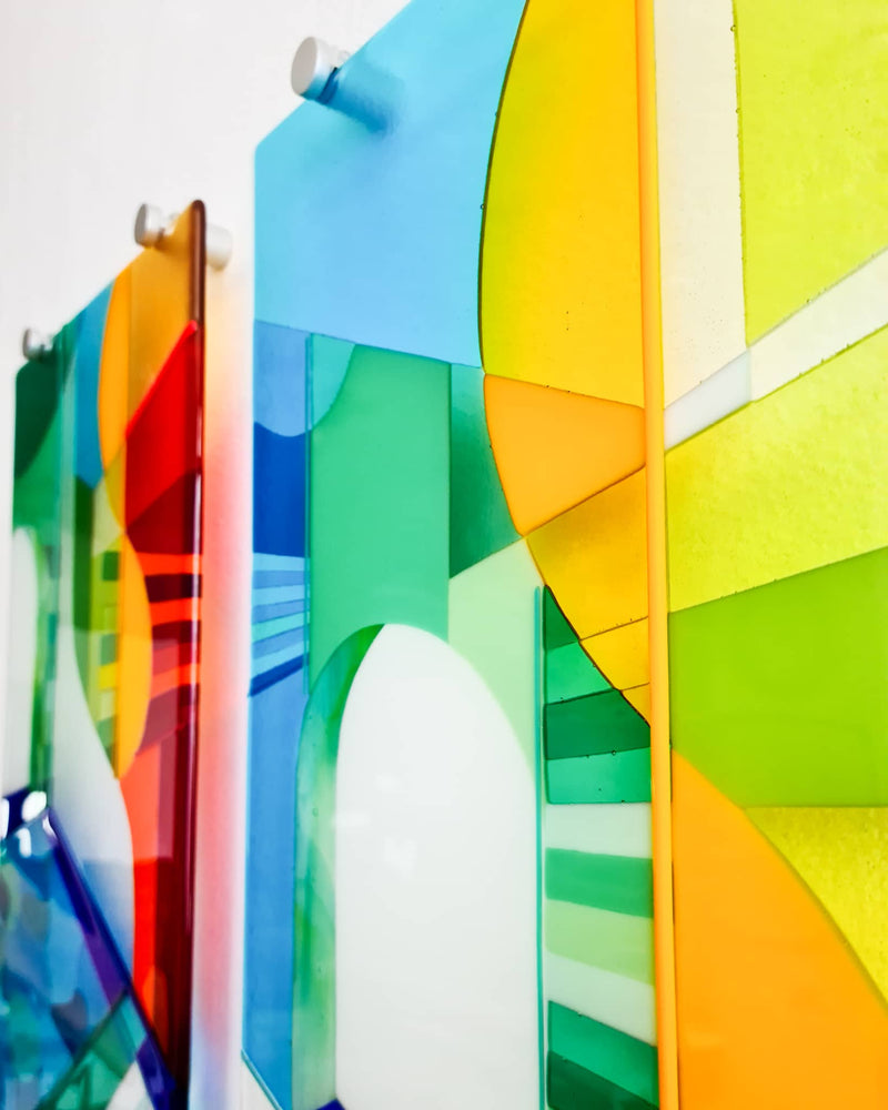 Angled side view of the two Biarritz glass wall panels in blue, green, yellow, orange and red