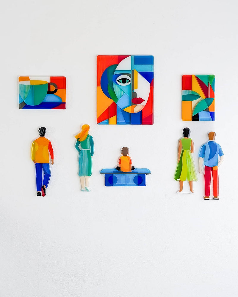 Gallery contemporary glass wall art composition with colourful portraits, figures, a cup and a seated person arranged across eight pieces