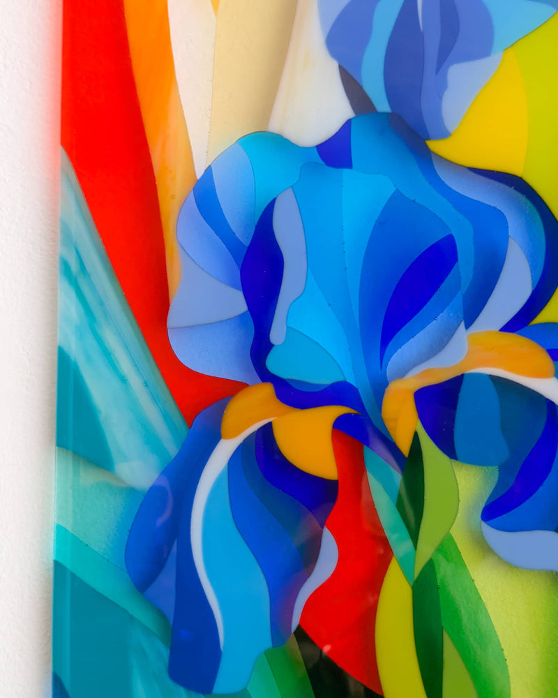 Close-up of the commissioned contemporary Hard Edge glass iris artwork showing vivid blue iris petals and flowing abstract colour created from individually hand-cut glass pieces