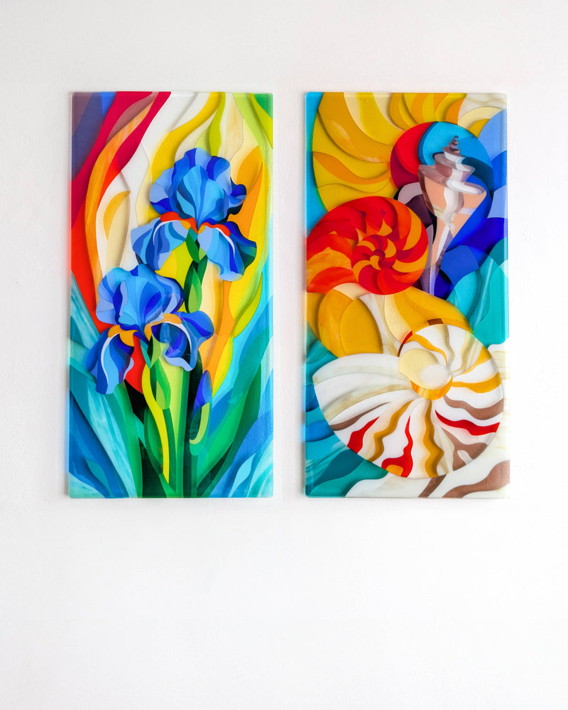 Gardening and The Sea displayed together as two contemporary fused glass wall panels, one featuring blue irises and the other colourful shells