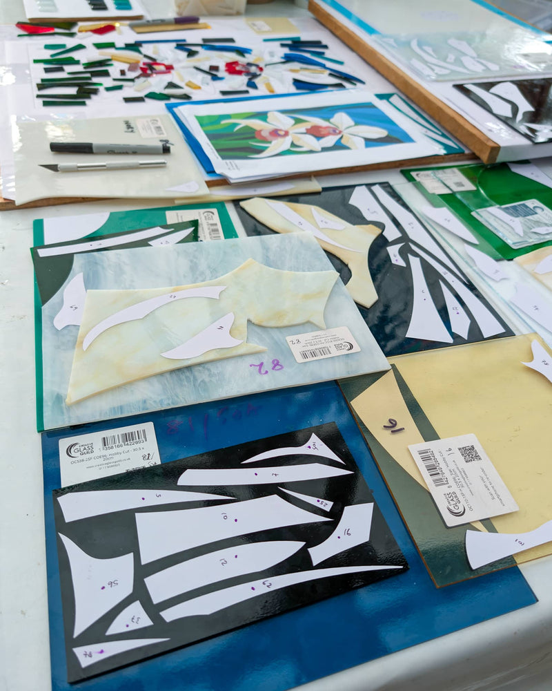 Work in progress creating 'Orchid', a commissioned contemporary Hard Edge glass artwork with individually cut glass pieces prepared for precise assembly before kiln firing