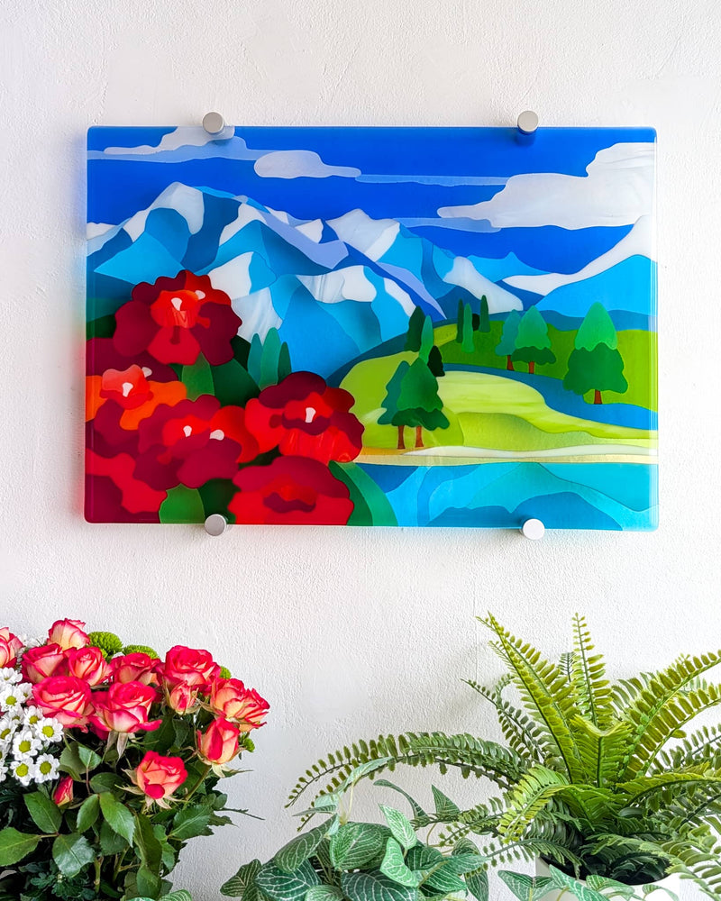 Shangri-La contemporary fused glass wall panel with blue mountains, red rhododendrons, green hills and a lake