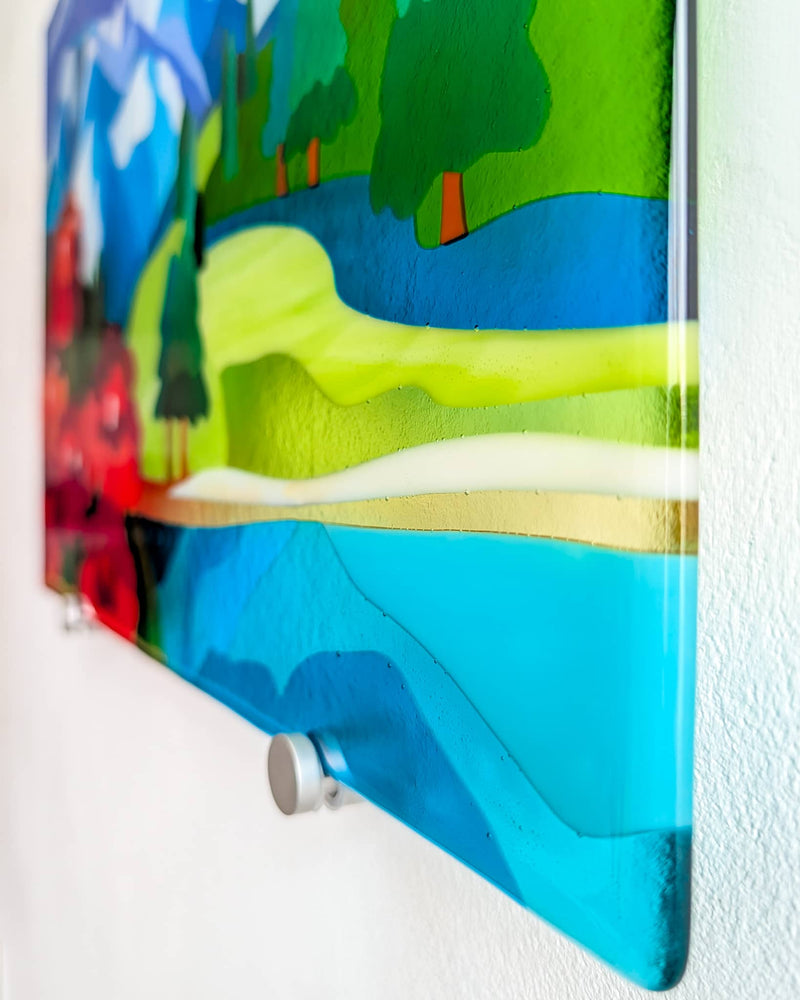 Side view of the Shangri-La glass wall panel showing blue water, green hills and the metal wall fixing
