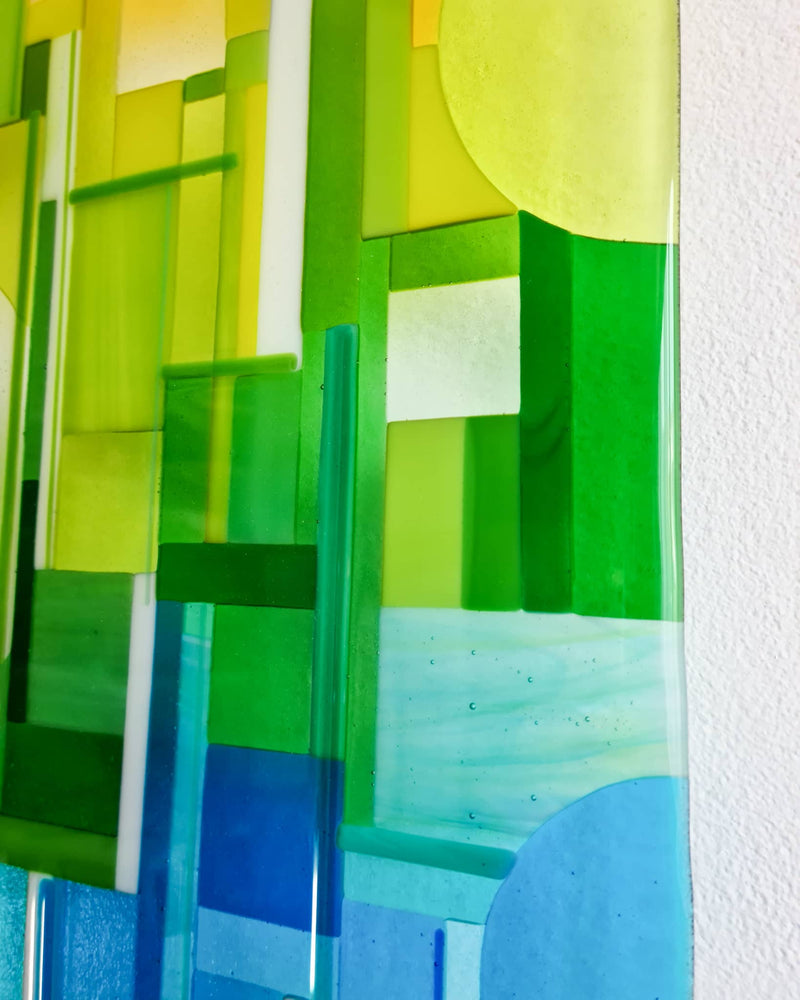 Close-up of Spectrum showing green and blue glass offcuts, circular shapes and slender glass rods