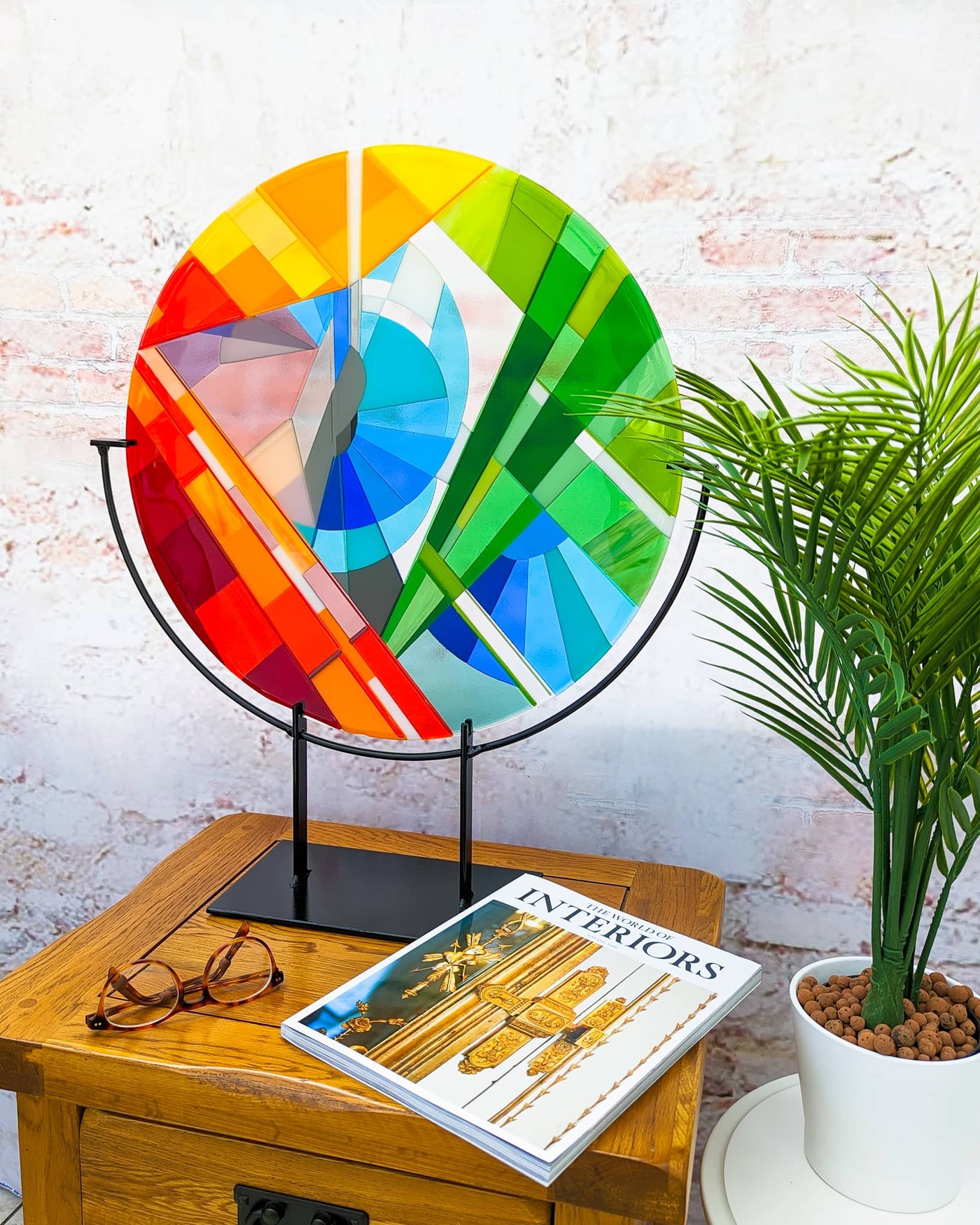 'Stairs' contemporary Hard Edge glass roundel displayed on its steel stand in a contemporary interior setting