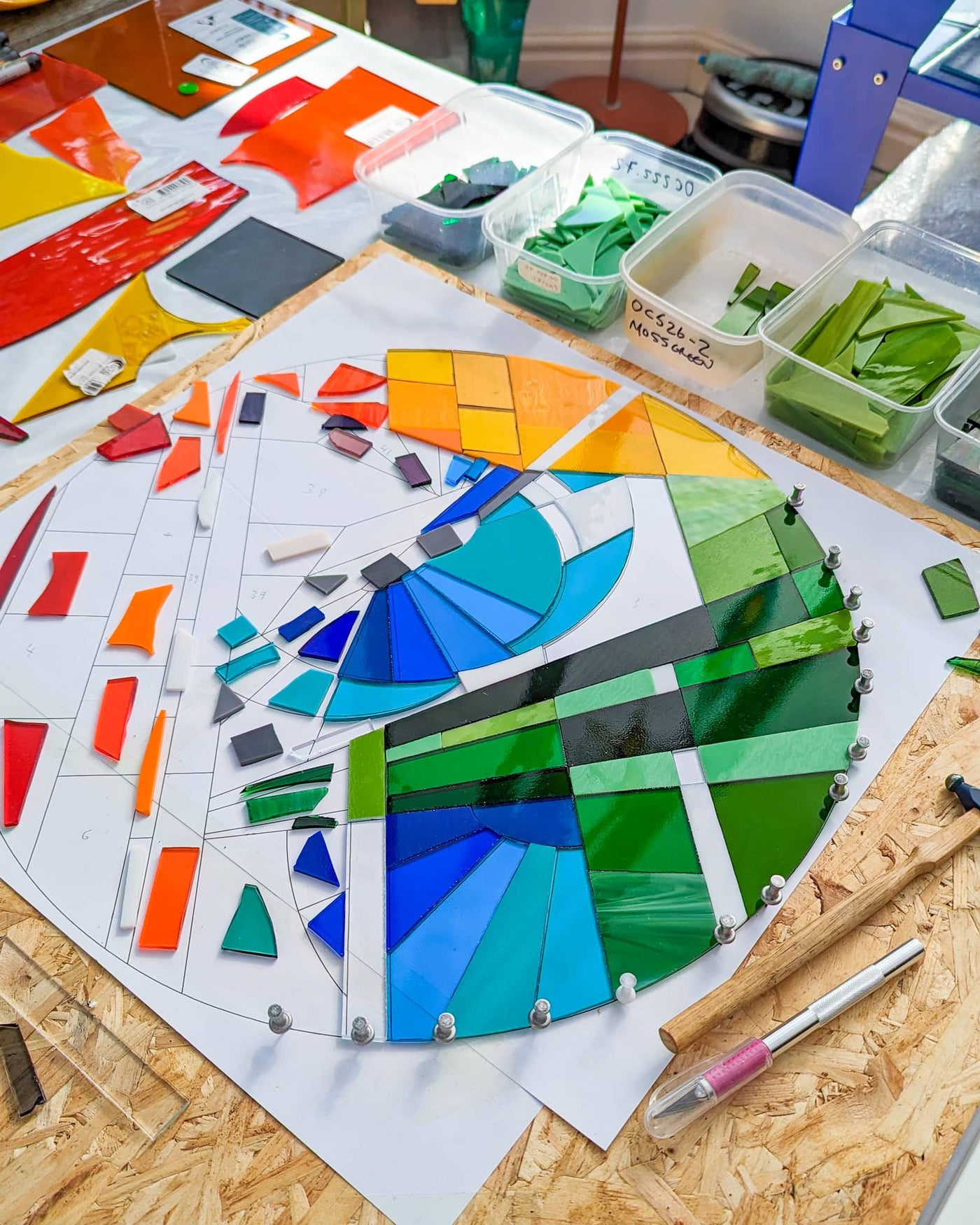Work in progress on 'Stairs' showing individually cut glass pieces being positioned before kiln firing alongside colour studies and the finished design