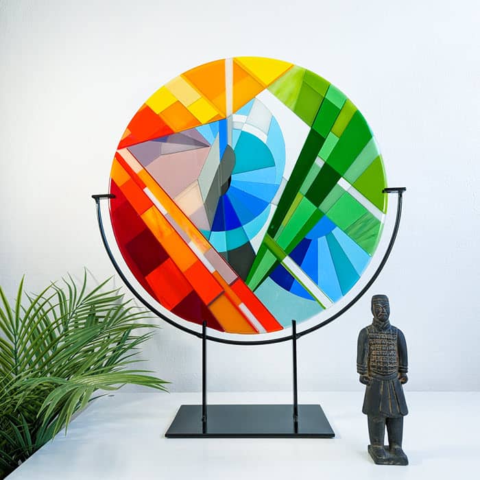 'Stairs' contemporary Hard Edge glass roundel by Linda Rossiter, inspired by the main staircase in Manchester Art Gallery and displayed on its steel stand