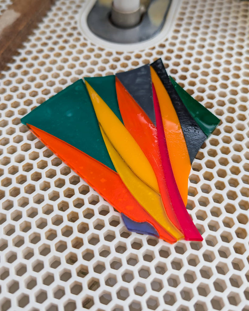 Work in progress creating a contemporary Hard Edge glass birds of paradise artwork showing individually cut glass pieces assembled before kiln firing