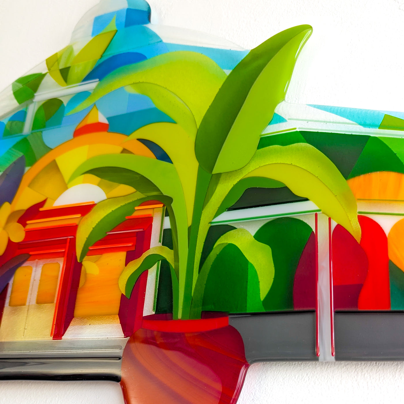 Close-up of 'Palm House' contemporary Hard Edge glass artwork showing the large tropical plant, surrounding foliage and architectural glasshouse forms