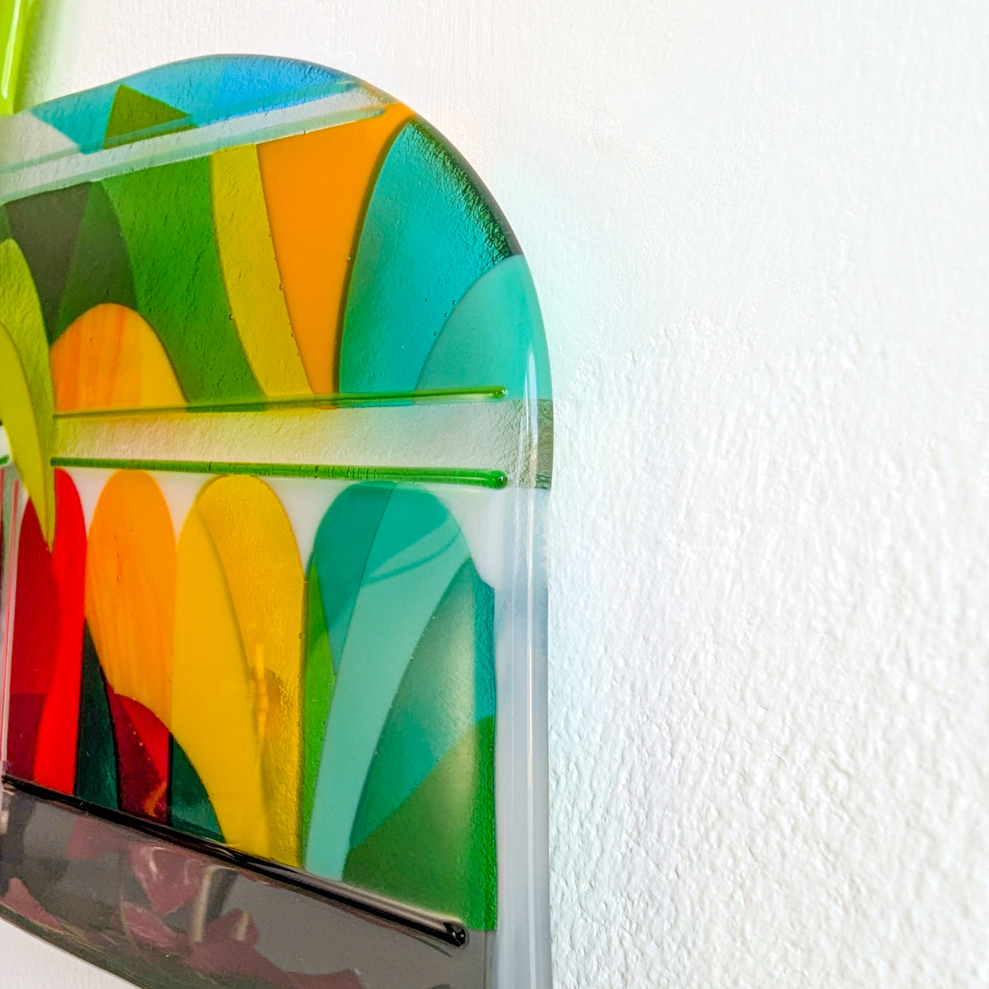 Side detail of 'The Palm House' fused glass artwork, showing layered botanical forms and two fine green stringers fused into the surface for added line and texture.