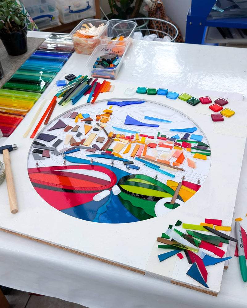 Work in progress creating the commissioned Vernazza Hard Edge glass artwork, with individually cut glass pieces forming the colourful town, sea and boats