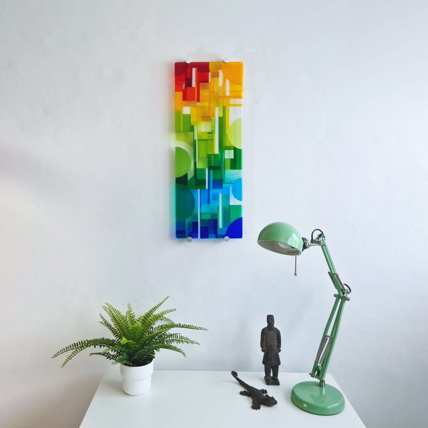 'Spectrum' contemporary Hard Edge glass wall artwork displayed in a modern interior, showing its vertical format and interaction with natural light